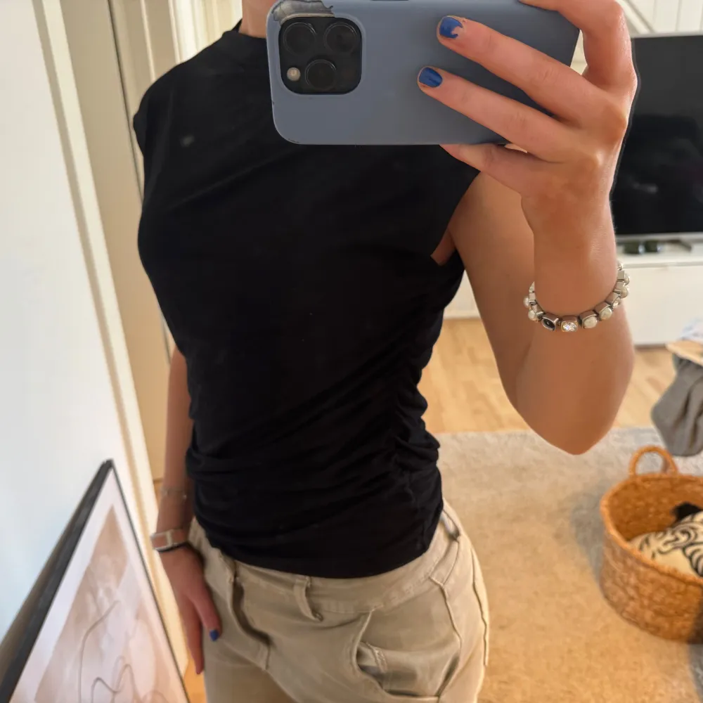 Säljer en stilren svart topp med tight passform. Toppen är ärmlös och tillverkad i ett mjukt material som ger en bekväm känsla. Perfekt för en minimalistisk look.. Yläosat.