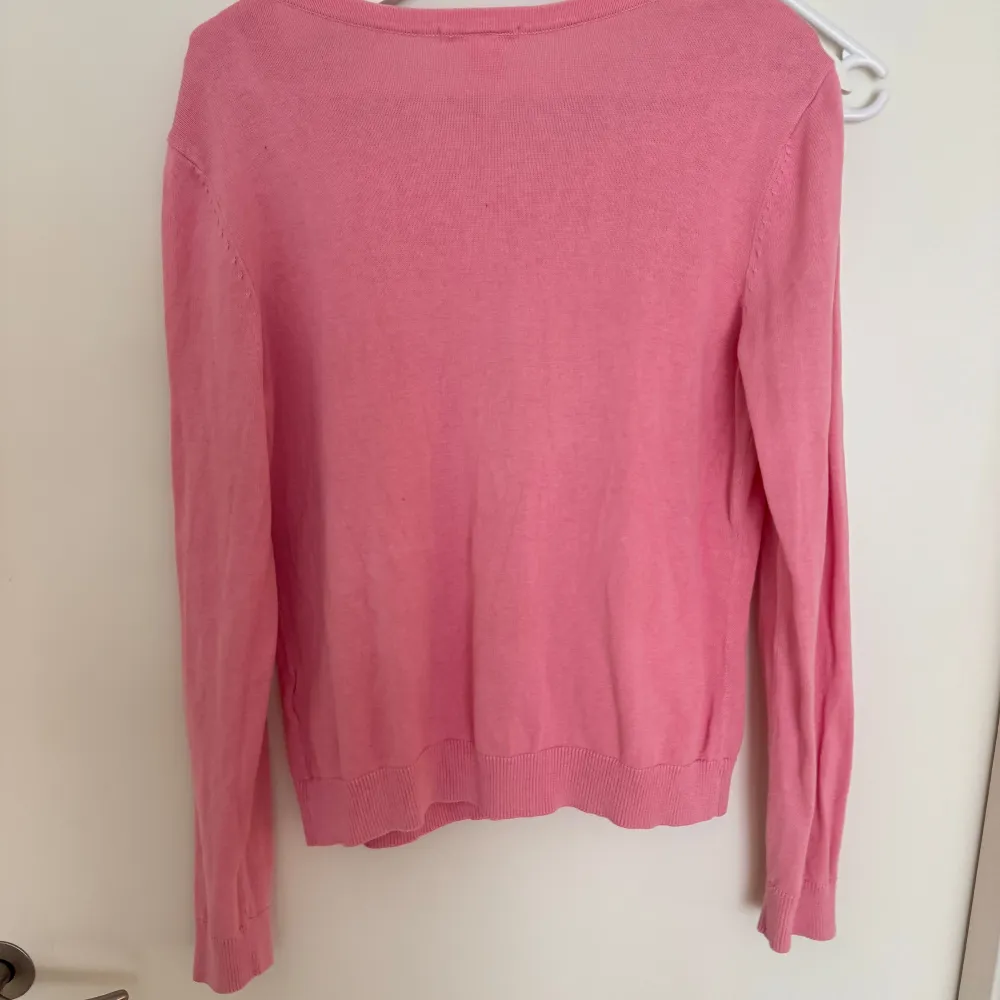 Säljer en söt rosa kofta från Basic med knappar framtill. Koftan har en rund halsringning och långa ärmar. Perfekt för att lägga till en färgklick i din garderob!. Neuletakit & Villapaidat.