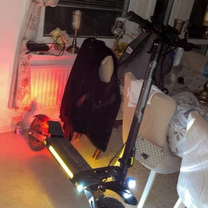 Svart elscooter  - Säljer en svart elscooter från Angwatt med digital display och LED-lampor. Scootern har robusta hjul och en stabil ram, perfekt för smidig transport i stan. Den är utrustad med en tydlig hastighetsmätare och batteriindikator. Perfekt för dig som vill ha ett miljövänligt transportmedel.