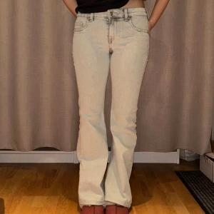 Ljusgråa bootcut jeans från H&M - Snygga ljusgråa bootcut jeans med låg midja. De har en femficksdesign och stängs med dragkedja och knapp. Använda 1 gång. Jag har även kortat ner de i benen så att de passar mig perfekt som är 162cm lång. 😍