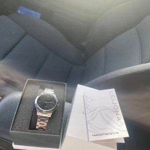 Silverfärgad klocka från Leijona - Säljer en stilren silverfärgad klocka från Leijona. Klockan har en svart urtavla och ett armband i rostfritt stål. Perfekt för den som söker en klassisk och tidlös accessoar. Levereras i originalförpackning med garantibevis.
