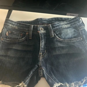 jeansshorts - Säljer ett par jättesnygga mörkblåa jeansshorts från Avery straight med en cool amerikansk flagga på bakfickan. Perfekta för en avslappnad sommarlook. Passar perfekt för varma dagar! Funkar perfekt att vika upp om man vill ha de kortare!💓