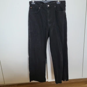 Svarta loose straight jeans - Snygga svarta loose straight jeans från &Denim med hög midja. Byxorna har en cool slitsdetalj vid fållen och är perfekta för en avslappnad stil. Passar bra till både sneakers och boots.