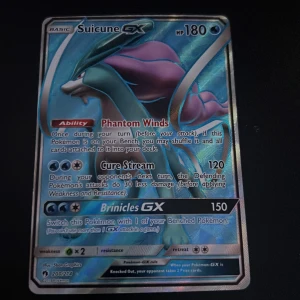 Suicune GX Pokémonkort - Säljer ett Suicune GX Pokémonkort med 180 HP. Kortet har förmågan Phantom Winds och attackerna Cure Stream och Brinicles GX. Perfekt för samlare eller spelare som vill stärka sin kortlek. Kortet har en holografisk yta som ger det en extra glans. Skriv om ni är intresserade.