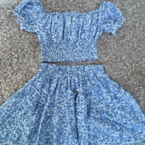 Blå blommig klänning med volangdetaljer - Sjukt fint blåt sätt med kjol och tröja till perfekt för sommaren, kom privat för mer bilder 