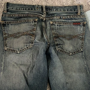 Blå jeans från Blend - Snygga blå vintage  jeans från Blend med en klassisk femficksdesign och subtila slitningar för en cool look. De har en normal passform och är tillverkade i 100% bomull för en bekväm känsla.