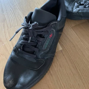 Svarta Adidas sneakers - Säljer ett par svarta Adidas sneakers med klassisk design och snörning. Skorna har en diskret logga på sidan och en slitstark sula. Perfekta för en stilren look.