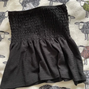 Svart kjol från Gina Tricot - Säljer en svart kjol från Gina Tricot. Kjolen är elastisk upptil och utsvängd nertill, prefekt till en stilren look.