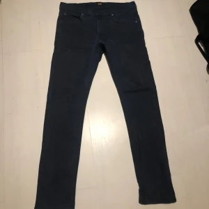 Mörkblå jeans från Lee - Snygga mörkblå jeans från Lee i modellen Luke. De har en klassisk femficksdesign och en smal passform som ger en stilren look. Perfekta för en avslappnad stil. Priset är inte hugget i sten!😊
