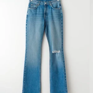 Blå bootcut jeans från Gina Tricot - Snygga blå bootcut jeans från Gina med slitningar på ena benet. Har används en gång men inga tecken på användning. Bra i längden på mig som är 163 cm lång. Skriv vid funderingar eller fler bilder 💞