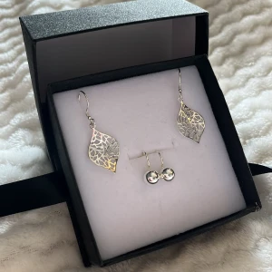 Silverörhängen i två olika stilar från guldfynd  - Säljer ett set med två par silverörhängen. Det ena paret har ett elegant, lövformat design med ett intrikat mönster, medan det andra paret är enkla och stilrena med små silverkulor. Allt i ett. 