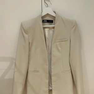 Beige kavaj från Zara - Beige kavaj från Zara med en stilren design. Har även tillhörande byxor om man är intresserad. 