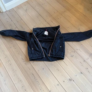 Svart vindjacka från Moncler - Svart/mörkblå moncler windbreaker.   Endast 1100kr    Strlk 1 vilket är som Small.    Väldigt bra skick. QR koden fungerar.