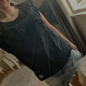 Svart volang blus spetsdetaljer - Snygg svart topp med fina spetsdetaljer vid nederkanten.  Enkel och stilren design som passar till det mesta.