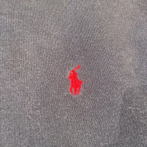 Mörkblå hoodie från Ralph Lauren - Säljer en snygg mörkblå hoodie från Ralph Lauren med dragkedja och det klassiska röda logotypen på bröstet. Perfekt för en avslappnad stil. Storlek 14/16. Hel, ren och fin men lite urtvättad. Ny pris 1200 kr. En liten liten fett fläck finns tyvärr också.