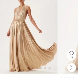 Balklänning  - Elegant champagne/guldfärgad långklänning från djup v-ringning och halterneck. Klänning passar perfekt till en bal och är endast använd en gång. Nypris är 1600 kr.