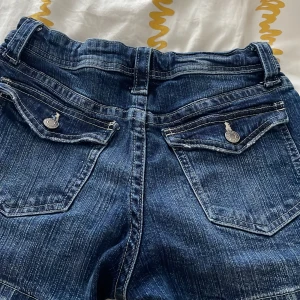 Blå jeansshorts med fickor - Snygga blå jeansshorts med klassisk femficksdesign och knappdetaljer. Perfekta för en avslappnad stil.