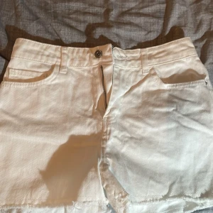 Vit jeanskjol från Teen Blue - Säljer en vit jeanskjol från Teen Blue i storlek 38. Kjolen har klassisk femficksdesign, bälteshällor och rå kant nedtill för en avslappnad look. Perfekt till sommaren och enkel att matcha med olika toppar. Det passar för s ochså 