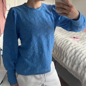 Blå spetsmönstrad tröja från Object - Säljer en blå blus med långa ärmar från Object med rund halsringning. Blusen har ett genomgående spetsmönster med fina detaljer och lätt puffade axlar. Perfekt sommarblus och känns helt oanvänd🥰