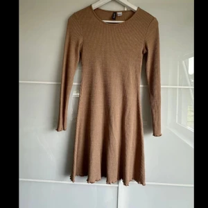 Beige ribbad klänning från H&M Divided i S - Säljer en beige ribbad klänning från H&M Divided. Klänningen har lång ärm, rund halsringning och är tillverkad i ett mjukt stretchigt material. Använt den max 2 ggr.