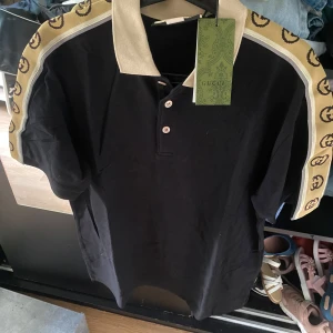 Gucci polo T-shirt - Gucci polo y shirt använd en gång för ett familjebröllop.       Det är bra för sommartid. Storlek M men den är lite stor på mig så den fungerar även för personer som bär L