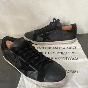  Golden Goose superstar - Säljer ett par svarta Golden Goose som är riktigt feta inför sommaren och kommande säsonger. Dem har en stil som gör att de ser slitna ut vilket gör att de blir unika. De är använda 2 gånger och är otroligt sköna och stilrena. Låda medföljer ej 