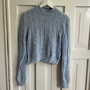 Ljusblå fluffig tröja från Forever 21 - Supermjuk och fluffig ljusblå tröja från Forever 21 med hög hals och lång ärm. Tröjan har en croppad passform. Stretchig men passformen står L men skulle säga mer S-M