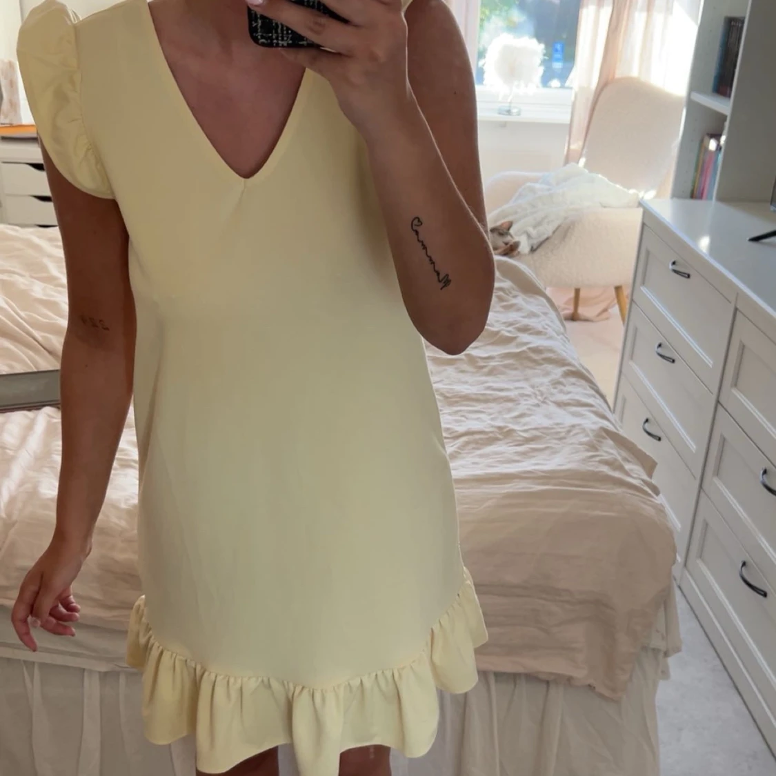 Ljusgul klänning med volangdetaljer