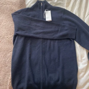 Mörkblå full zip  i kashmir från Soft Goat - Mörkblå långärmad ziptröja från Soft Goat i 100% kashmir. Tröjan har hög krage och hel dragkedja. Endast testad så i nyskick