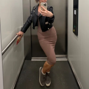 Ribbad brun långärmad klänning från NLY Trend - Säljer en ribbad, figurnära klänning i brun nyans från NLY Trend. Klänningen har lång ärm, rundad halsringning och är tillverkad i mjukt stretchigt material. Perfekt för dig som gillar en enkel men stilren look.