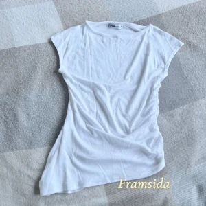 Vit enkel t-shirt - Säljer en klassisk vit t-shirt med rund hals och korta ärmar. Modellen är rak med utvidgad kant på ena sidan, och ihopsytt med mer format på andra sidan. Det blir en snygg design! Materialet är mjukt och lätt. Köpte den för ca 110 kr ny, endast testad hemma, aldrig lämnat huset med den!✨🤍🫶🏻 Strl är S.