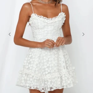 Vit blommig studentklänning  - Superfin studentklänning med tunna axelband, volangdetaljer och ett blommigt mönster i spets. Aldrig använd då jag har en annan klänning till studenten💕Nypris 1400kr säljer för 1000 men går ner i pris vid snabb affär!