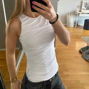 Vit ärmlös linnetopp - Säljer detta vita linne som passar perfekt till sommar och våren, den sitter tajt💘