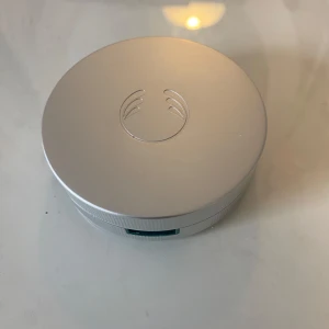 Kompaktpuder från The Body Shop - Säljer ett kompaktpuder från The Body Shop i en rund, silverfärgad dosa med spegel i locket. Pudret är ljust beige och passar för en naturlig finish. Perfekt att ha med i väskan för snabba touch-ups under dagen.