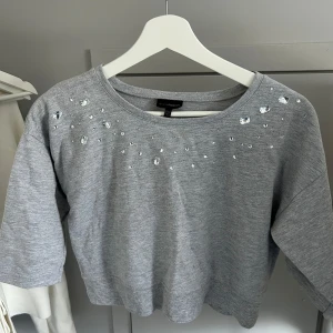 Grå magtröja med pärldetaljer - Säljer en super fin grå magtröja från Kappahl med pärldetaljer vid halsringningen🩶Passar mig som brukar ha S