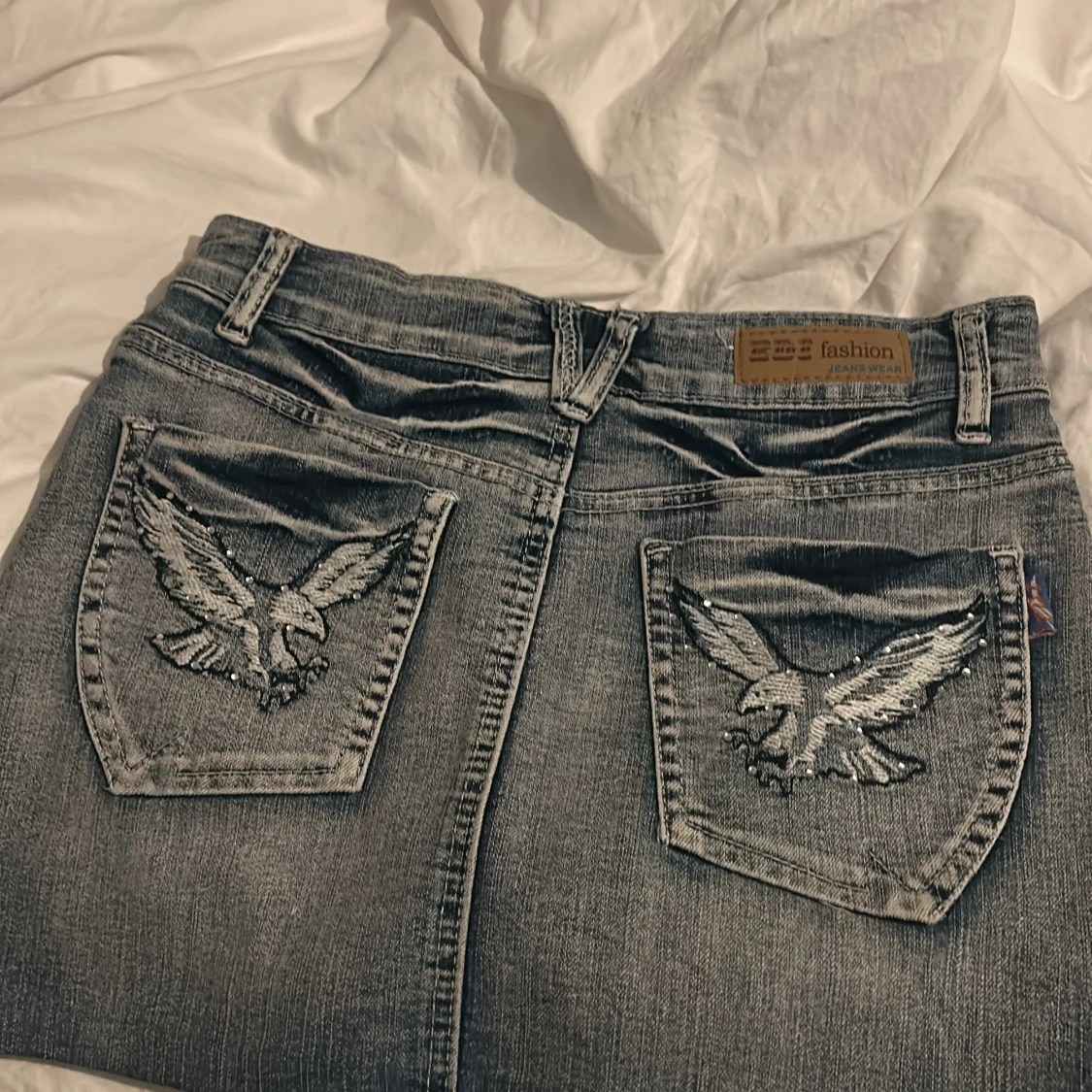 Ljusblå jeanskjol med broderad örn från EDI Fashion