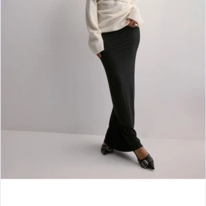 Svart långkjol - Elegant svart långkjol. Perfekt för både vardag och festliga tillfällen. Aldrig använd prislapp kvar!