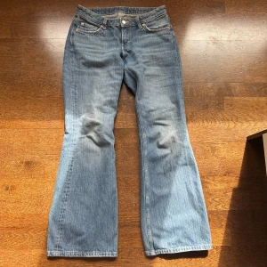 Blå bootcut jeans från Weekday - Säljer ett par klassiska blå jeans från Weekday i modellen Nova Low Slim Bootcut. Jeansen har låg midja, bootcut-ben och fem fickor. Använda fåtal gånger