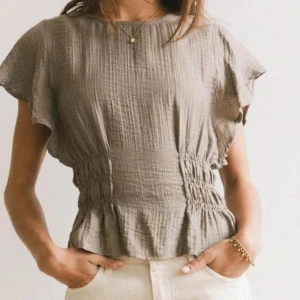 Beige blus med resår i midjan - Jättebra skick. Ljuset på andra bilden är lite konstig. Men första bilden är lånad.