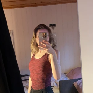 Röd och svart randig träningslinne - Snygg och bekväm röd och svart randigt träningslinne. Toppen har en tight passform tar ut ens former bra. Toppen är sparsamt använd🩷🖤 Stl XS