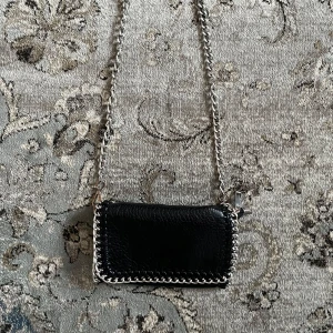 Silver Kedje väska i svart läder / tiamo väska - Kedje väska i svart läder med silver kedja från märket tiamo💕 köptes ny hos Scorett för 499kr och väskan är i strl S. Säljs då den ej kommer till användning längre. Mått syns på bilderna men skriv gärna om ni vill veta mer 🤗kolla in vad mer jag säljer och gör gärna ett bundle och för att få 10% rabatt!☺️