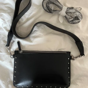 Väska - Oanvänd väska från Åhléns! Medföljer 2 band. 