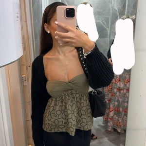 Grön blommig tubtopp - Toppen har en twistad detalj framtill och är ärmlös. Använd få gånger ca 2-3 är i bra skick. 