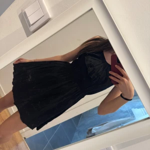 Svart klänning - Snygg svart klänning med en kort längd. Perfekt för en kväll ute eller en speciell tillställning. Klänningen har en enkel och elegant stil som framhäver figuren.