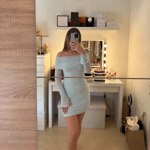 Ljusblå offshoulder klänning - Säljer ljusblå offshoulder klänning med långa ärmar. Denna är köpt från Gina och är i storlek S. Använd 1 gång. 