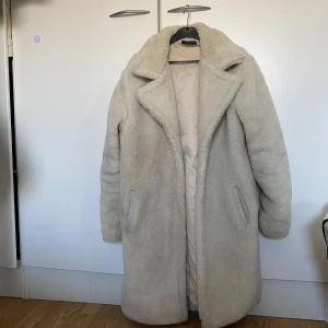 Beige teddyjacka från Trendyol - Mysig vit teddyjacka från Trendyol. Jackan har en klassisk krage och långa ärmar, perfekt för kyliga dagar. Den är gjord i ett mjukt och fluffigt material.