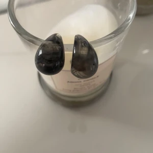 Svarta droppformade örhängen - Snygga svarta droppformade örhängen med en glansig yta. Perfekta för att ge en elegant touch till din outfit.