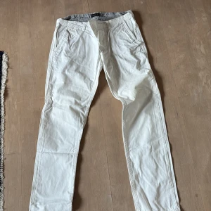 Vita byxor från East West - Snygga vita byxor från East West i bomull. De har en klassisk design med normal passform och midwaist. Perfekta för en stilren look.