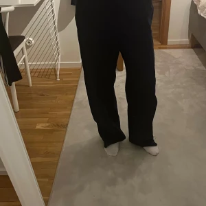 Mörkblå linne byxor  från Zara - Säljer ett par mörkblå byxor från Zara med avslappnad passform. Byxorna har raka, vida ben och resår i midjan för extra komfort. Perfekta för en chill och stilren look.