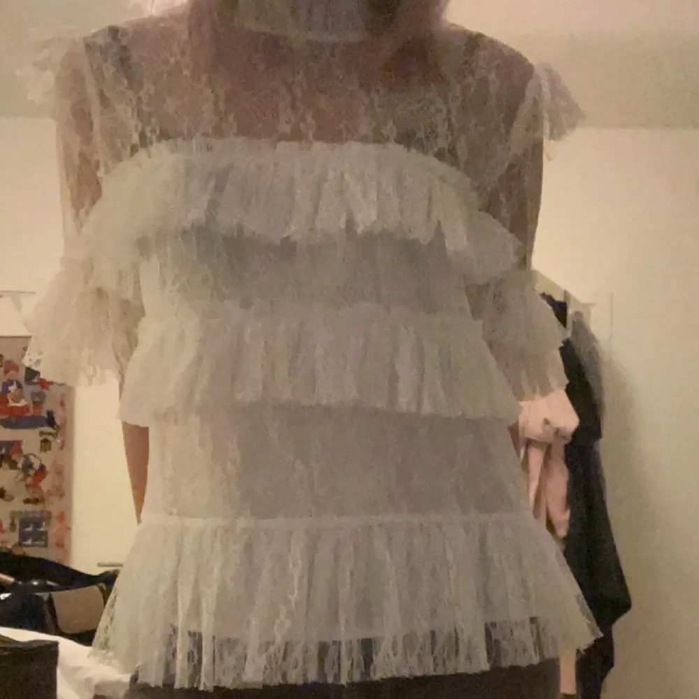 Säljer min by malina Rachel blus. Den är i jätte fint skick och har inga defekter. En romantisk vit blus i spets med flera lager volanger både framtill och på ärmarna. Blusen är genomskinlig och har korta ärmar. Perfekt för dig som gillar en feminin och trendig stil! Hör av er vid frågor eller intresse! Postar inom 24h💕💕💕den passar s/m🥰. Puserot.